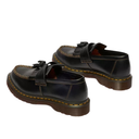 Pair of black loafers with brown soles on a white background