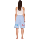 Woman wearing light blue shorts with 'Evie' printed on them against a white background