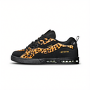 A black low-top sneaker with a bold leopard print pattern in orange, black, and brown across the side panels, featuring a black sole and yellow 'VMD' branding on the heel.