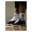 Person wearing black sneakers and white socks with 'globe' logo on a concrete surface.