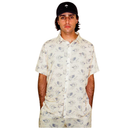 Man wearing a patterned shirt and cap on a white background