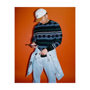 Person wearing a striped sweater and light blue jeans against an orange background