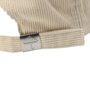 Beige ribbed knit beanie with a metal tag featuring an umbrella symbol on a white background
