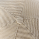 Close-up of a textured beige fabric with a button in the center