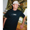Man wearing a black t-shirt with a logo in a room with decorative elements