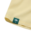 Close-up of a yellow fabric with a green label featuring an umbrella icon on a white background