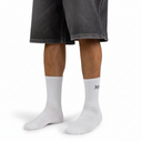 White socks with a logo worn by a person in gray shorts on a white background