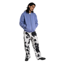 Person wearing a blue hoodie and cow print pants on a white background