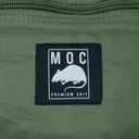 Close-up of a green fabric surface with a black label featuring a white logo and text.