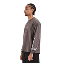 A man in profile wearing a dark brown long-sleeve t-shirt with white contrast panels on the sleeve and a small white chest logo, paired with black pants, against a plain white background.
