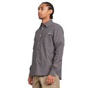 A man wearing a long-sleeve button-down shirt with a small-scale black and white gingham pattern, paired with khaki pants, shown from a side profile against a plain white background.