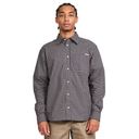 A man wearing a long-sleeve button-up shirt with a black and white micro-check pattern, paired with khaki pants, photographed against a solid white background.
