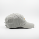 A light gray baseball cap with a small brown leather patch on the side, displayed inside a gray box.