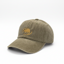 A washed olive green baseball cap with a yellow embroidered fish logo on the front, resting on a white surface against a gray background.