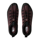 Pair of maroon sneakers with black soles on a white background