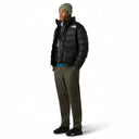 Person wearing the Limbara Jacket by The North Face and green pants on a gray background