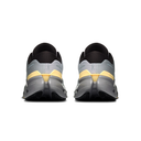 A pair of Nike running shoes shown from the back, featuring a gray and black upper with a distinctive yellow accent and a chunky gray and black sole.