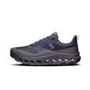 A dark gray and navy blue On running shoe with a chunky, cushioned sole featuring cutout details, shown from a side profile on a white background.