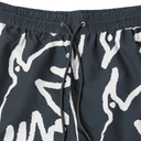 Black shorts with white abstract patterns and drawstring on a light gray background