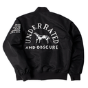Black satin bomber jacket shown from the back, featuring a large white graphic print of a goat inside the word 'UNDERATED' and the phrase 'AND OBSCURE' below it. The right sleeve has a smaller white graphic with text including 'MAN MADE HATE', 'DUST', 'MERMAID', and 'A DOG'.