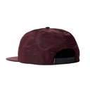 A maroon flat-brim snapback cap shown from the back, featuring a black adjustable strap with white 'FILA' branding.