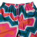 Colorful swim shorts with a geometric pattern on a white background
