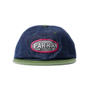 A dark blue denim snapback cap with a green flat brim and a central oval patch reading 'PARRA SOLITUDE' in white text with a pink border.