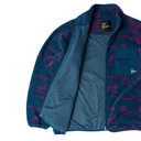 A close-up of a fleece jacket from the brand Piquadro, featuring a blue and purple camouflage pattern on the exterior and a solid teal blue interior lining. The jacket is shown open, displaying the pocket and inner texture, on a clean white background.