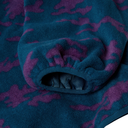 A close-up of a plush fleece blanket with a dark teal background and a purple abstract camouflage pattern, folded to show its soft texture and drawstring closure.