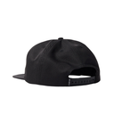 Black flat-brim snapback cap shown from the back, featuring a black adjustable strap with a small white 'FILA' logo on the side, set against a plain white background.