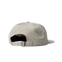 A light beige baseball cap shown from the back, featuring a curved brim and an adjustable strap with a metal slider, set against a plain white background.