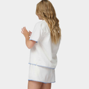 Woman wearing a white pajama set with blue trim on a white background