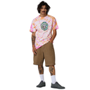 Person wearing a tie-dye shirt and brown shorts on a white background