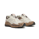 A pair of vintage Nike running shoes in off-white, brown, and black, displayed against a clean white background.