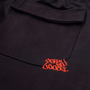 Black fabric with red embroidered text on a dark background