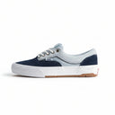 Navy and light blue sneaker with brown sole on a beige background