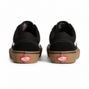 Black sneakers with brown soles and red Vans labels on a white background