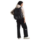 Person wearing a black backpack and black pants with The North Face logo on a white background