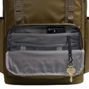 Close-up of an olive green backpack showing the front utility pocket opened to reveal gray interior compartments, a phone in the top pocket, and a key hanging from a zipper pull.