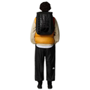 Person wearing a black backpack with 'The North Face' logo on a white background