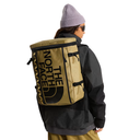 Person wearing a tan backpack with 'The North Face' logo on a white background