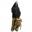 Person wearing a black jacket and tan pants holding a The North Face bag on a white background