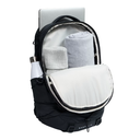 A black BORE-LIT backpack shown open, revealing a light gray interior organizer with a rolled towel, a white bottle in the side pocket, and a silver laptop inserted at the top, on a white background.