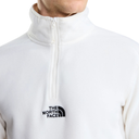 A close-up of a person wearing a white half-zip fleece pullover by The North Face, showing the black embroidered logo on the left chest against a plain white background.