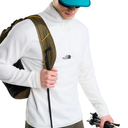 A man wearing a white The North Face quarter-zip fleece pullover, carrying an olive green and black backpack, with a teal cap and sunglasses, against a solid white background.