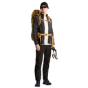 A man wearing a black beanie, sunglasses, a black jacket over a white shirt, black pants, and blue hiking boots, carrying a large tan backpack with a hiking harness system on a plain white background.