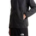 A close-up of a person wearing a black fleece jacket with a zippered front and side pocket, paired with black shorts featuring a white The North Face logo, against a plain white background.