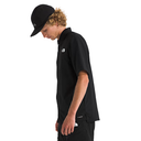 Person wearing a black shirt and cap with a visible brand logo on a white background