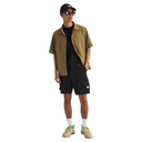 Person wearing a green shirt, black shorts, and a cap on a white background