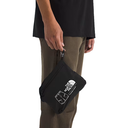 Person holding a black waist bag with a brand logo on a white background